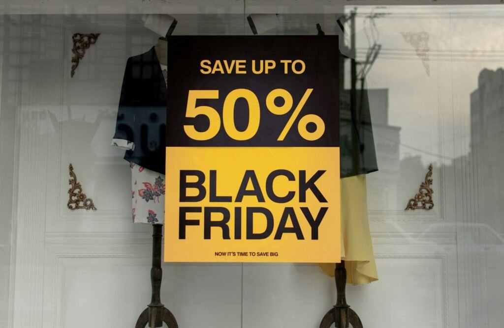 Black Friday sale poster offering up to 50% off hanging in a clothing shop window