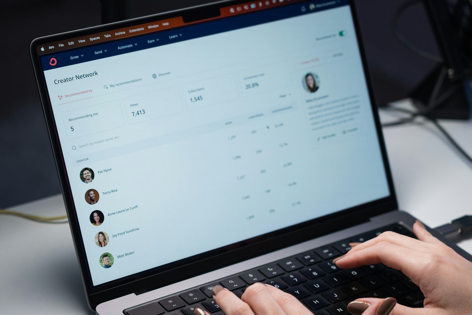 CRM software on a laptop showing a contact list with customer names and details