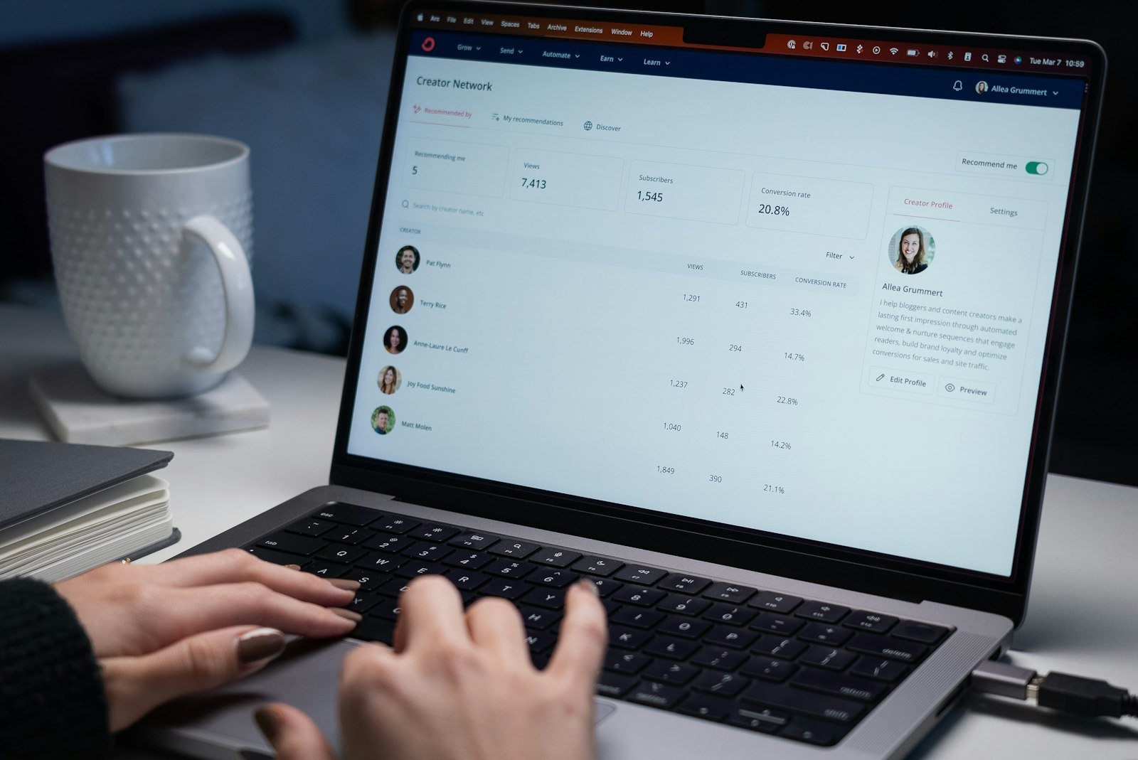Person typing on a laptop with a CRM contact record open on screen