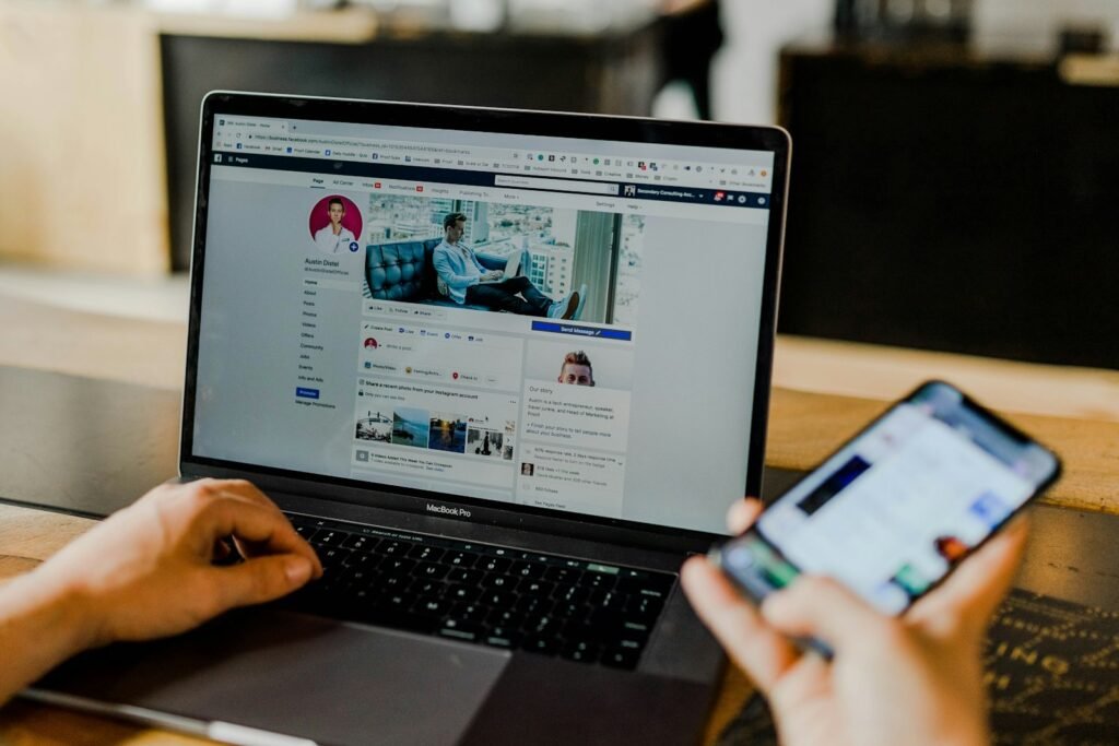 Person with Facebook open on a laptop and on a phone at the same time