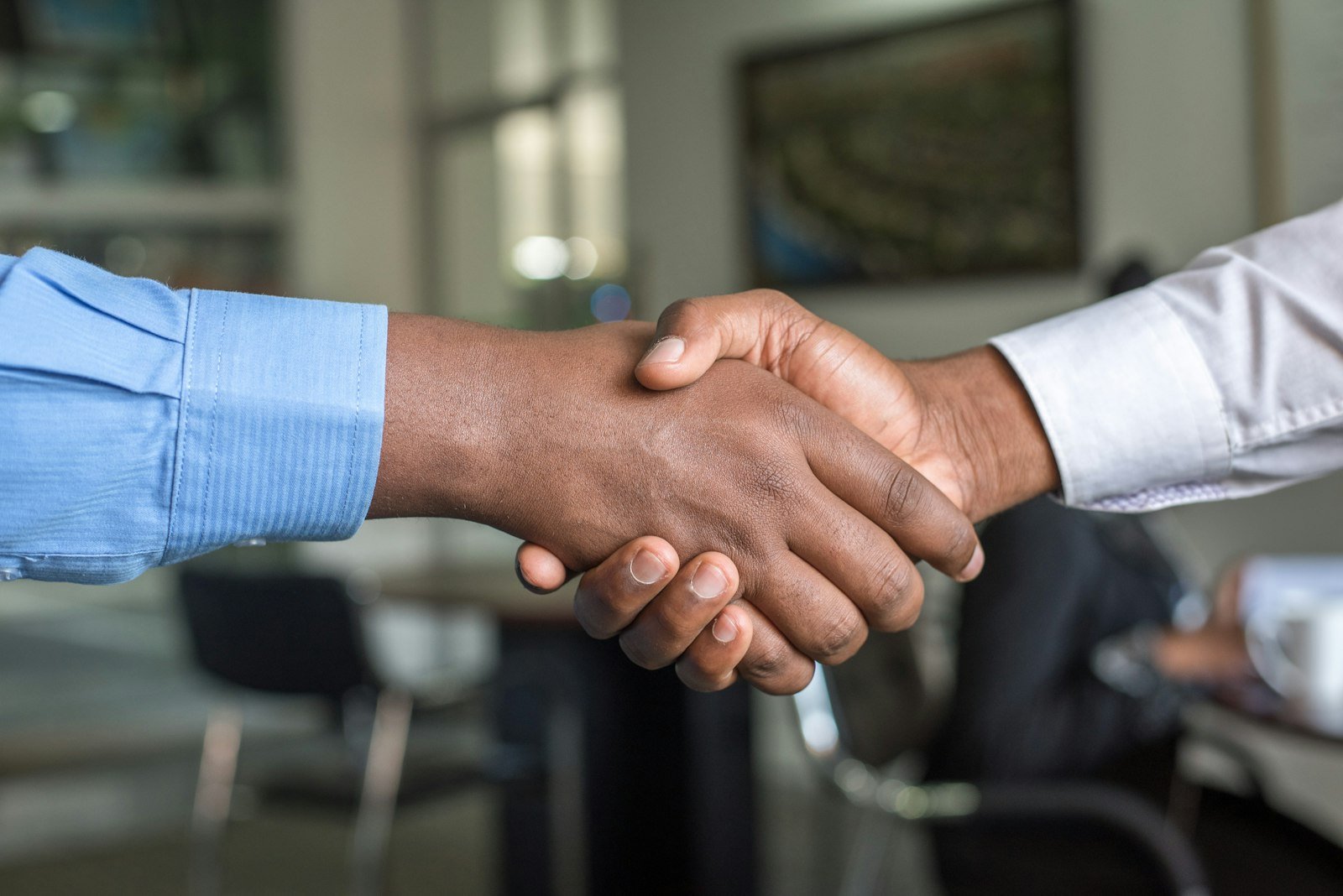 Close-up of two people shaking hands in an office