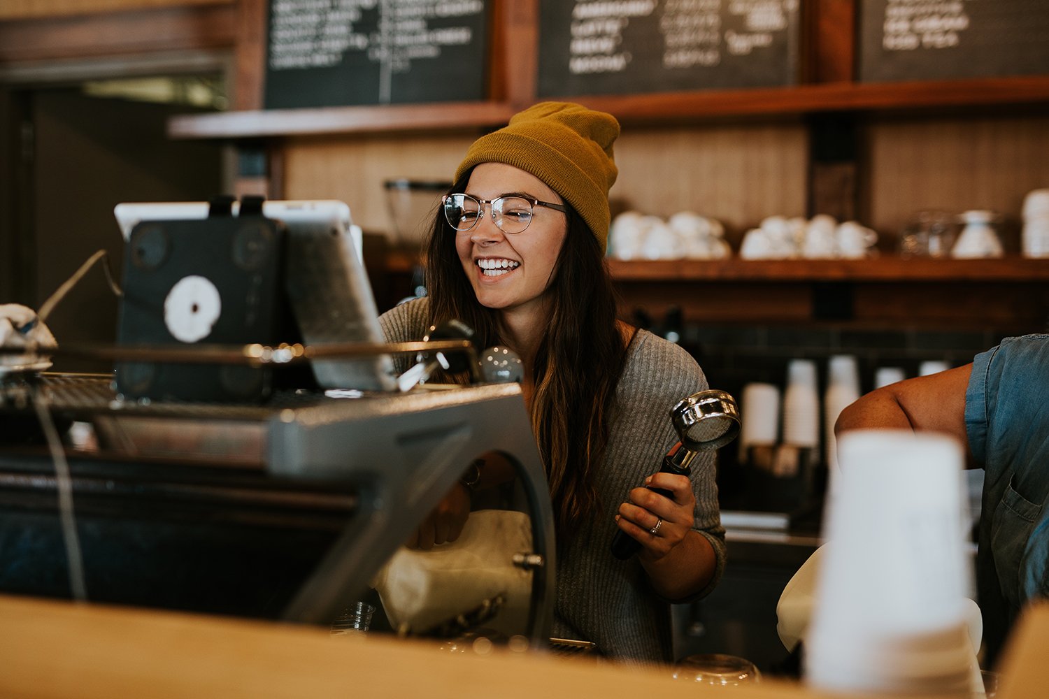 A business owner serving customers at the counter, too busy to answer the phone