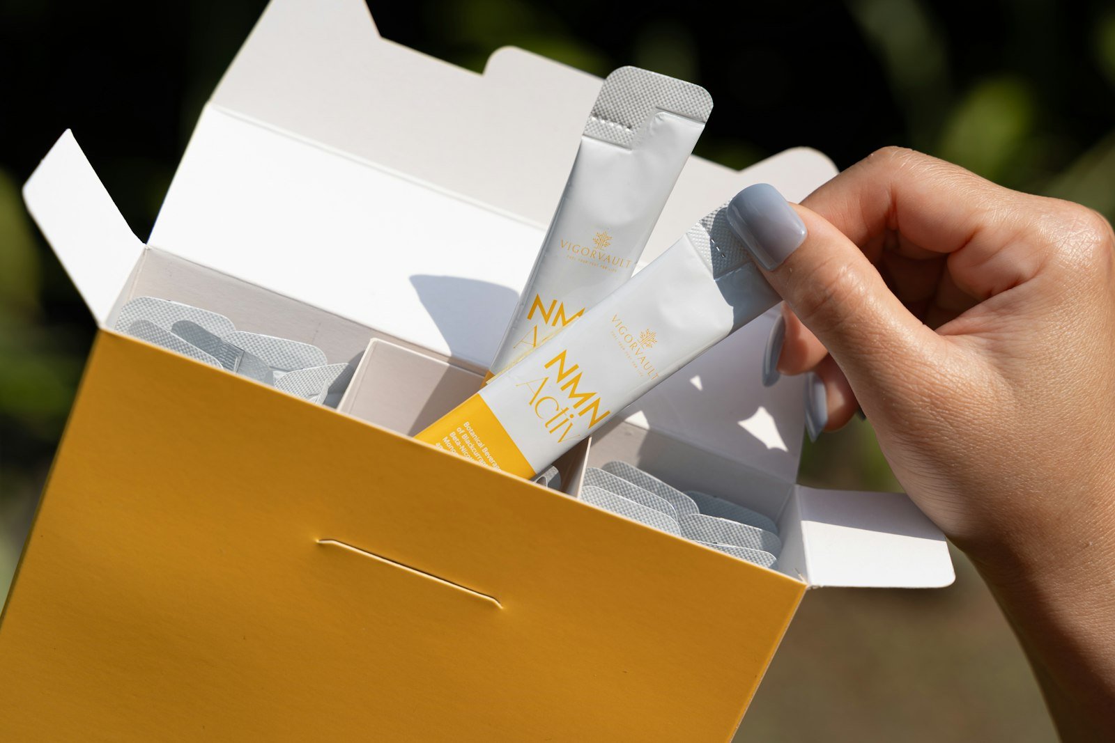 A hand taking product sample sachets out of a box