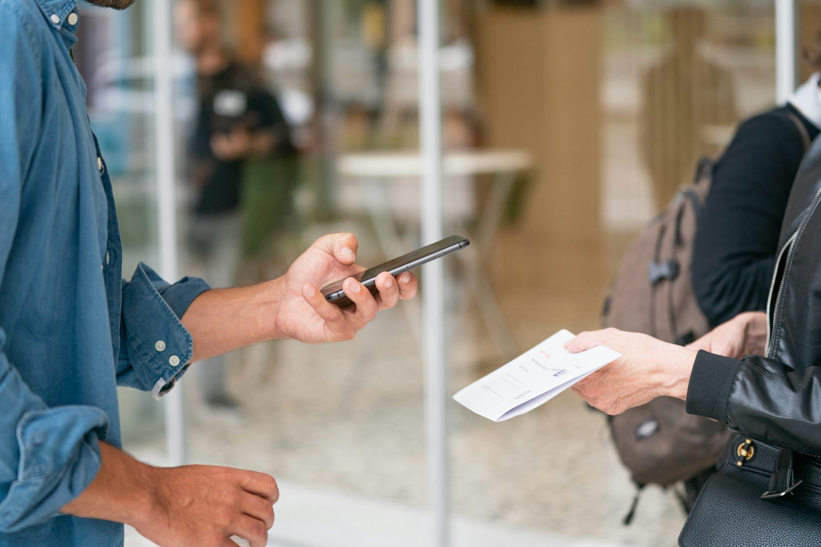 A visitor scanning a code with a phone held out by a staff member