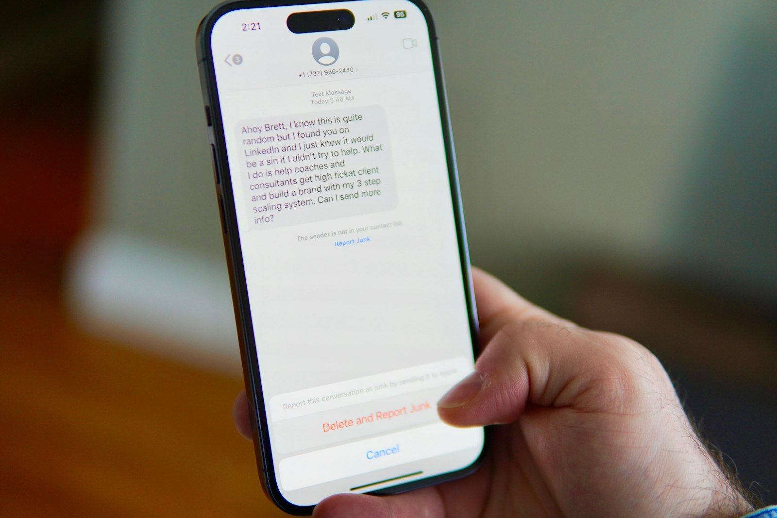 A hand holding a phone showing a text message conversation