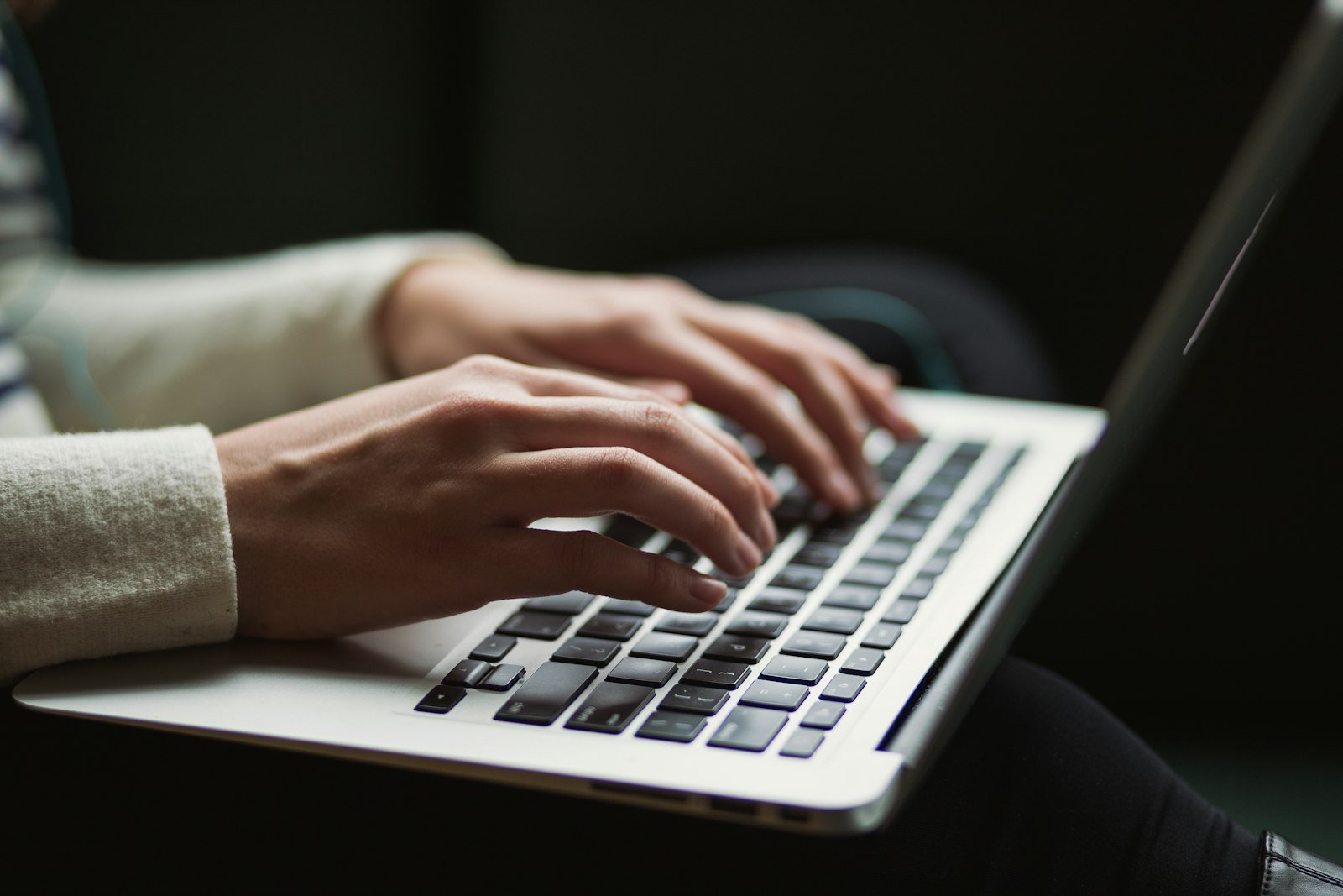 Hands typing a prompt on a laptop keyboard