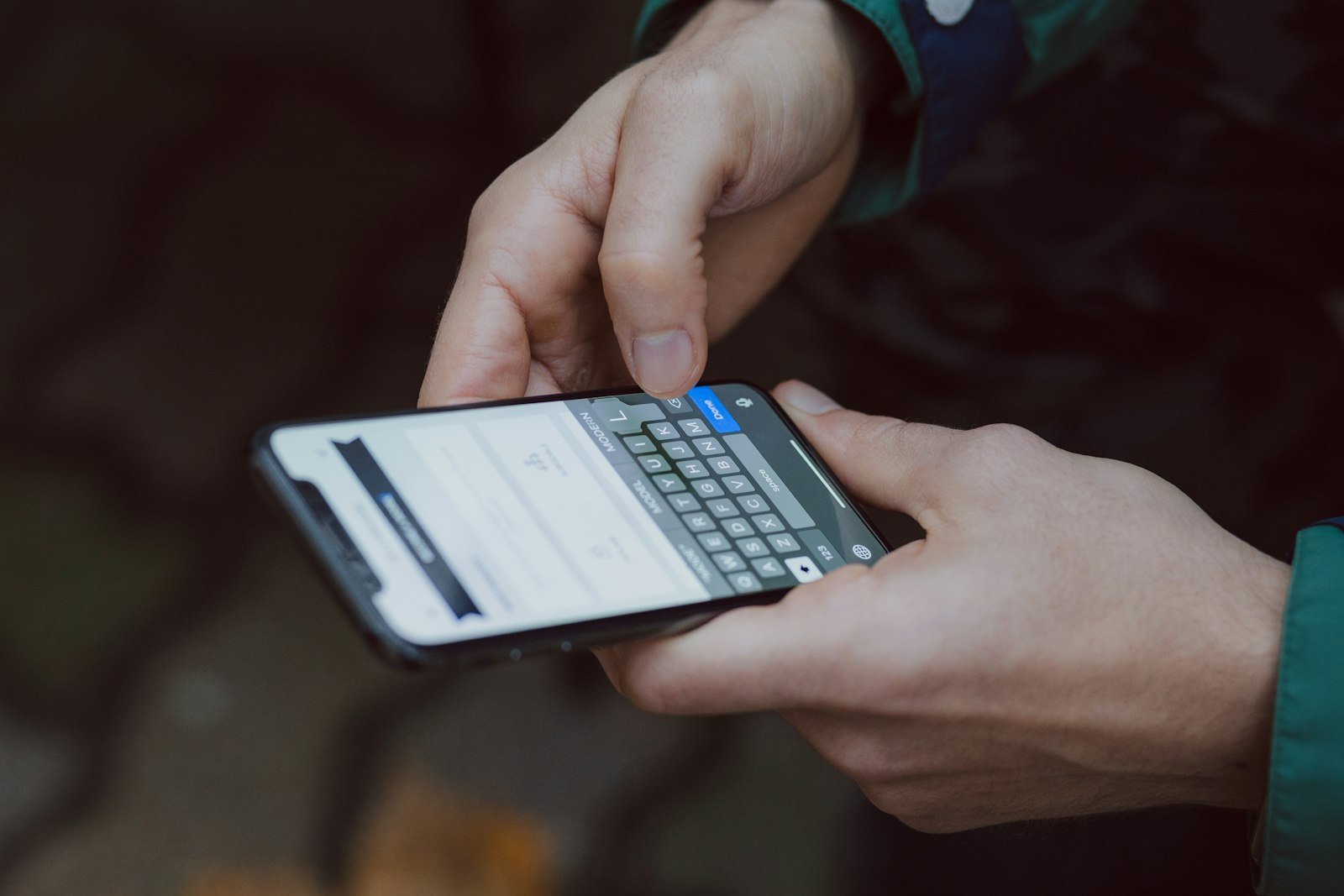 Hands typing a text message on a smartphone keyboard