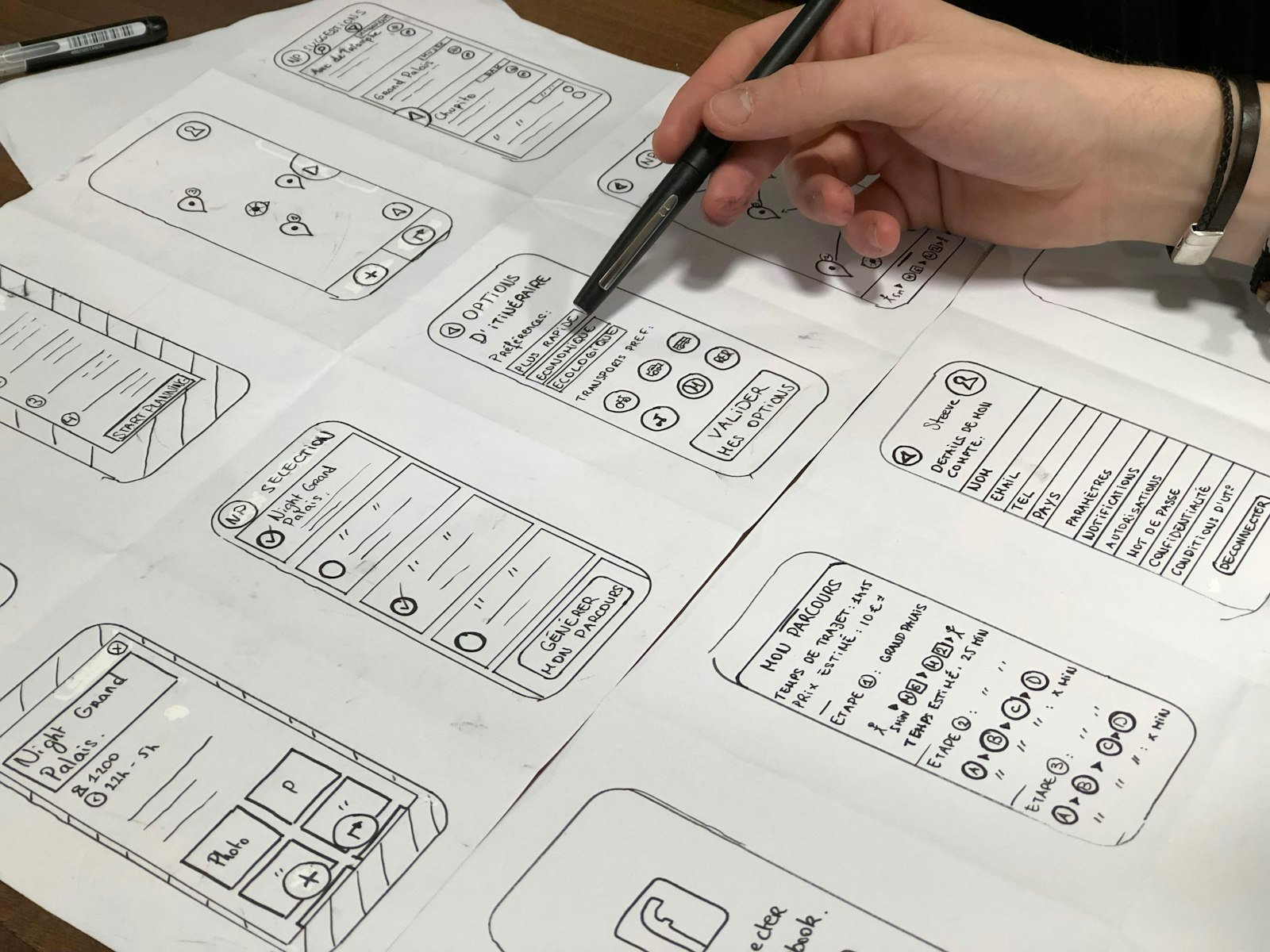 A hand sketching web page wireframes on paper